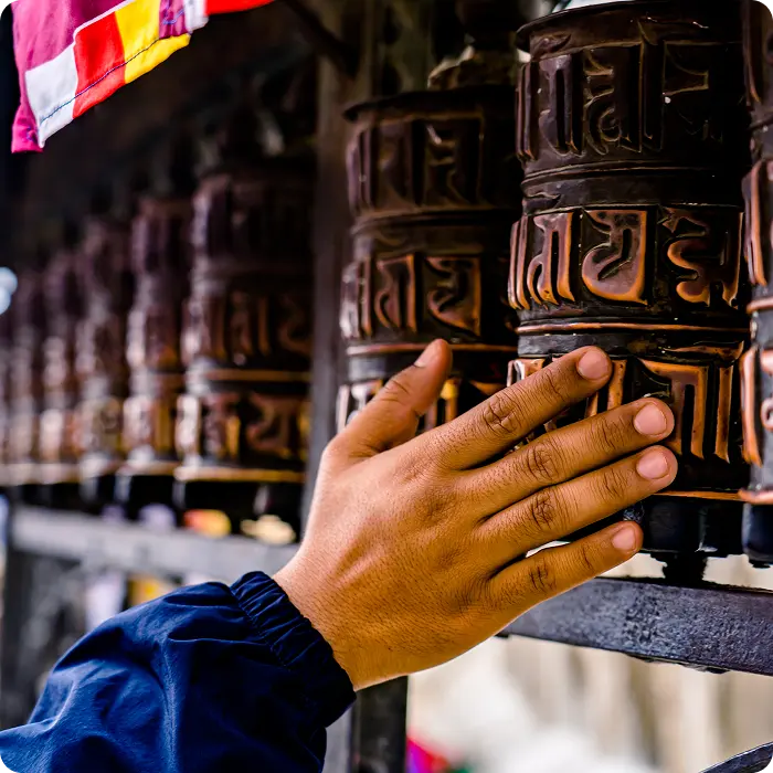 Un népalais qui tourne les moulins à prières d'une seule main